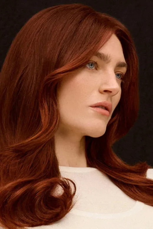 Model with glossy copper red hair, looking to one side