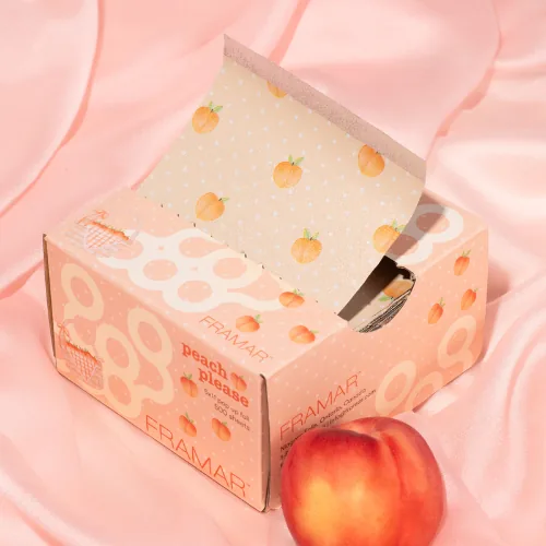 An open box of Framar Peach Please 5x11 pop up foils on pink silk beside a peach
