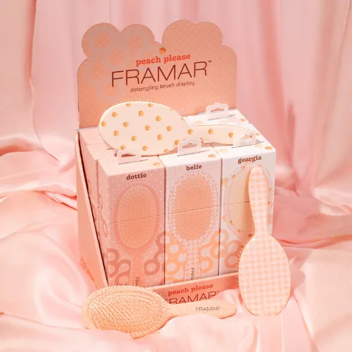 The Framar Peach Please nine brush counter display on pink silk, two brushes in front