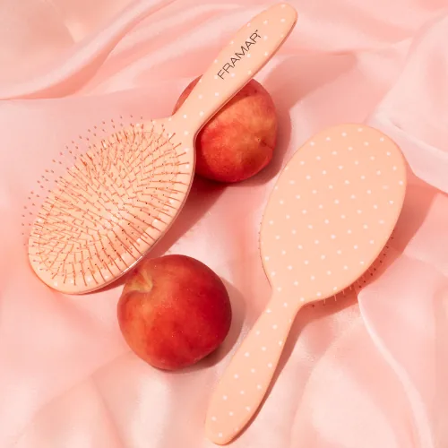 Two Framar Peach Please Dottie detangle brushes, peach with white dots, among peaches